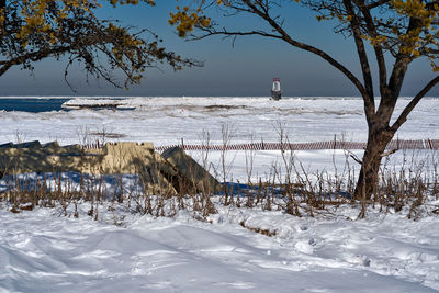 Scenic view of frozen field against sky during winter