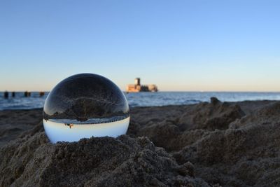 View of rocks on beach against clear sky