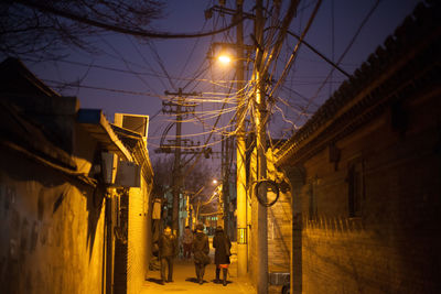 Low angle view of electricity pylon at night