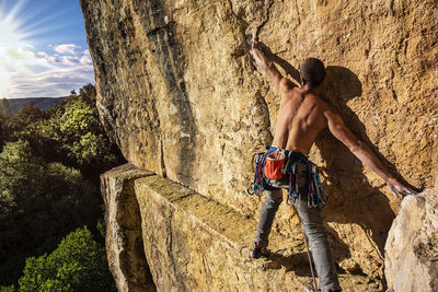 Full length of shirtless man standing on rock