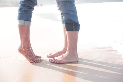 Low section of woman standing on beach