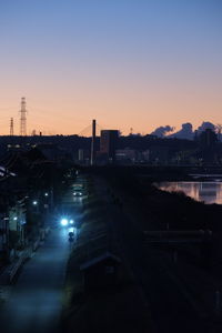 High angle view of illuminated city at sunset