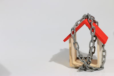 Close-up of red toy hanging on table against white background