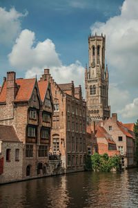 Canal and brick buildings with tree in bruges. a town full of canals and old buildings in belgium.