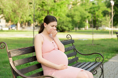 Woman sitting on bench in park