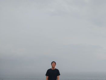 Rear view of man standing on mountain against sky