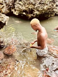 High angle view of boy playing in lake
