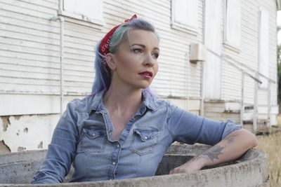 Thoughtful mid adult woman looking away while sitting outdoors