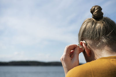 Man putting on hearing aid