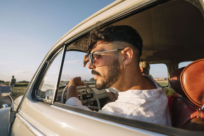 Gay couple travel in classic vintage car.