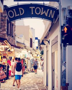 Rear view of people walking on street in city