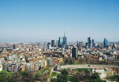 Aerial view of cityscape against sky during sunny day