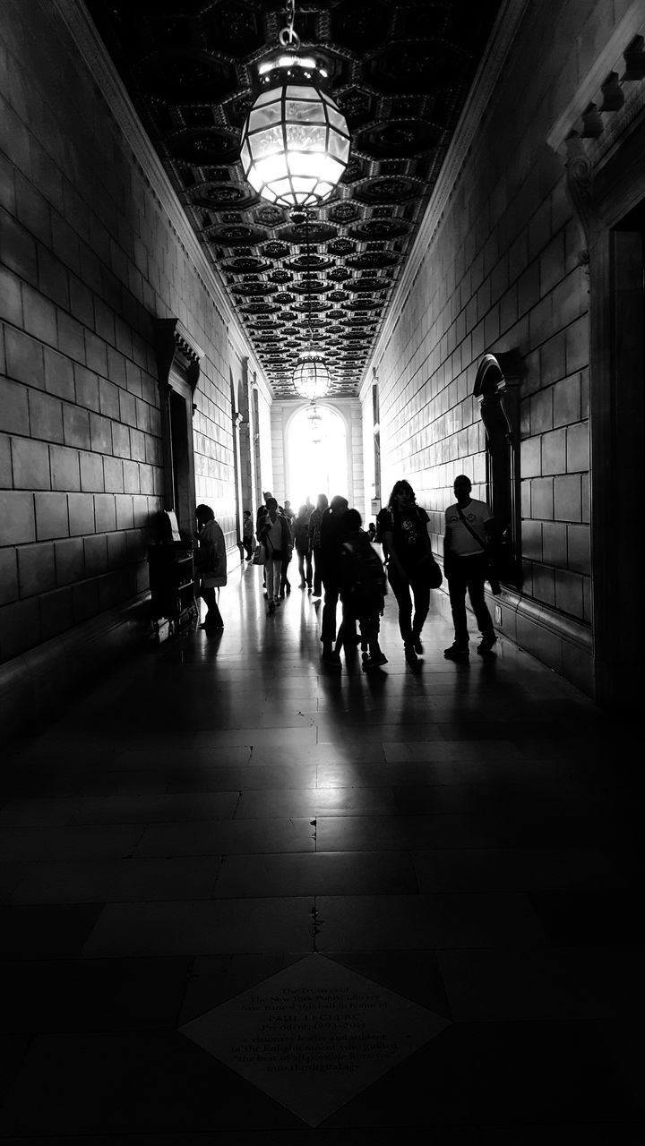 GROUP OF PEOPLE WALKING IN CORRIDOR