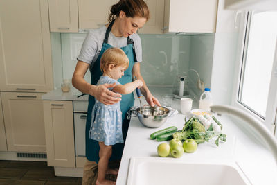 Side view of young woman holding food at home