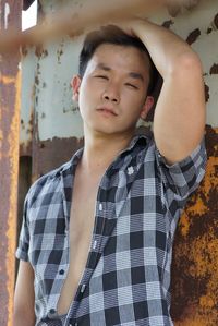 Portrait of young man against rusty metal