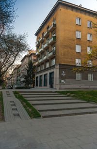 Residential building by street against sky
