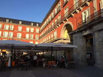 Group of people at restaurant against buildings in city