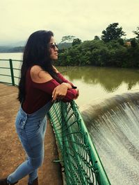 Full length of woman by lake against sky