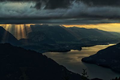 Scenic view of lake and mountains against dramatic sky