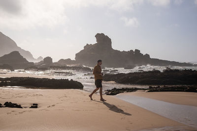 Rear view of man walking at beach