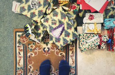 Low section of person standing by pile of wrapped presents