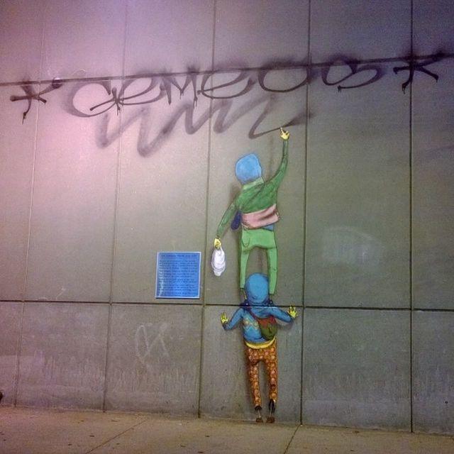 wall - building feature, multi colored, art, art and craft, creativity, built structure, hanging, indoors, wall, architecture, human representation, graffiti, one person, building exterior, day, toy, childhood, full length, painting, decoration