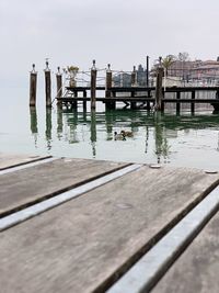 Wooden pier on lake against sky