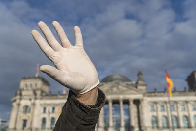 Midsection of man in city against sky