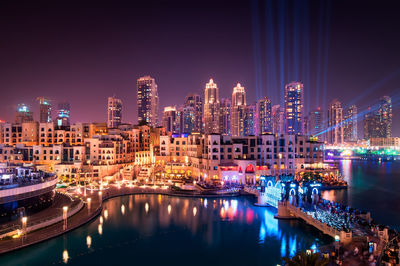 Illuminated buildings in city against sky at night