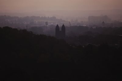 Silhouette of buildings against sky at sunset