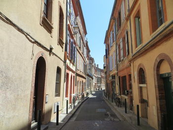 Narrow street amidst buildings against sky