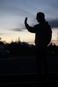 Full length of silhouette man photographing against sky