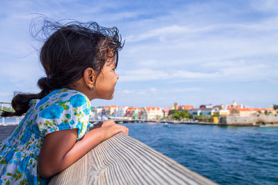 Side view of woman looking at sea against sky