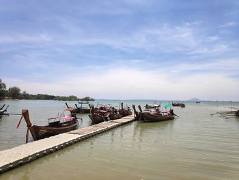 Boats moored in sea against sky