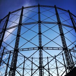 Low angle view of electricity pylon against blue sky