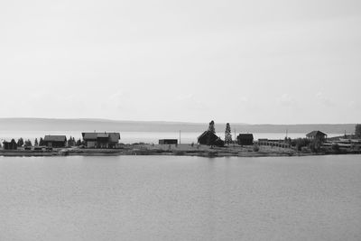 Scenic view of sea and buildings against clear sky