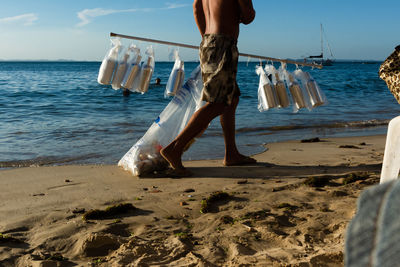  street vendor is seen walking on ribeira beach in the city of salvador, bahia.