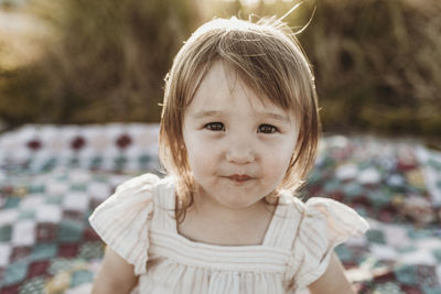 Close up portrait of young preschool-aged shy girl smiling