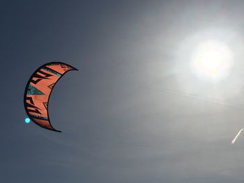 Low angle view of person paragliding against the sky