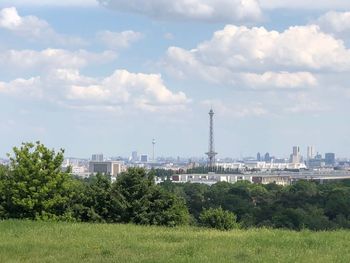 View of trees and buildings against cloudy sky