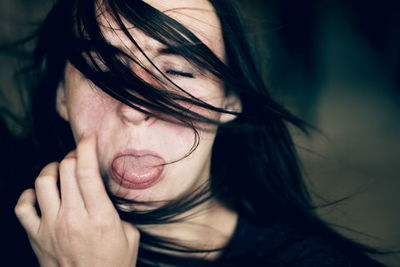 Close-up portrait of young woman over black background