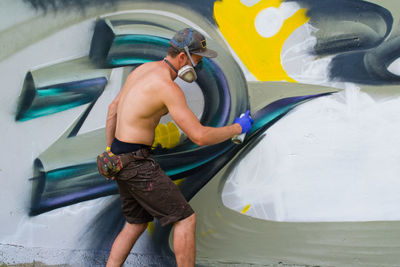 Man spray painting wall
