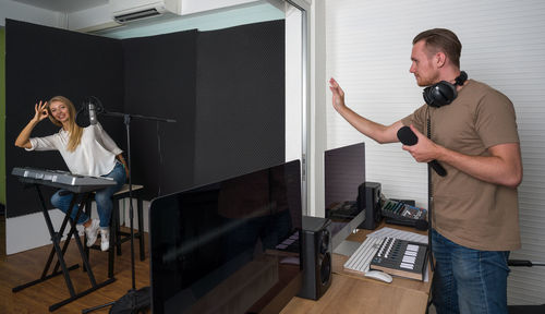 Man holding camera while standing on table at home