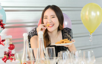 Portrait of a smiling young woman sitting at table