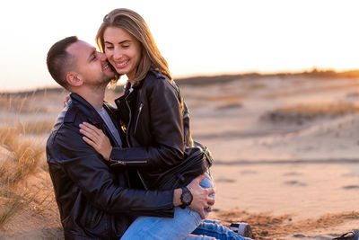 Side view of couple kissing on beach
