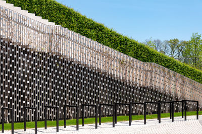 Fence by trees against sky