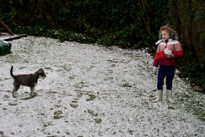 Full length of girl standing with dog