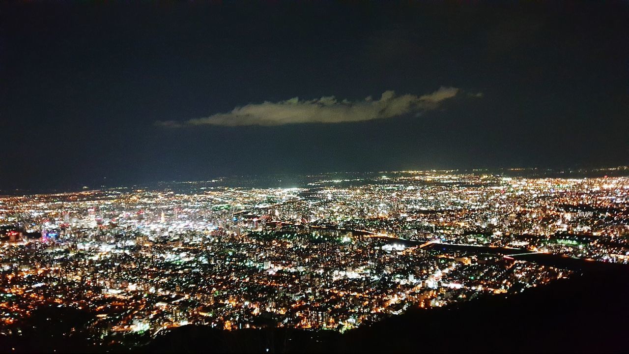 HIGH ANGLE VIEW OF ILLUMINATED CITY BUILDINGS AGAINST SKY