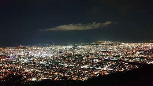 High angle view of illuminated cityscape against sky at night