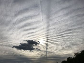 Low angle view of silhouette trees against dramatic sky